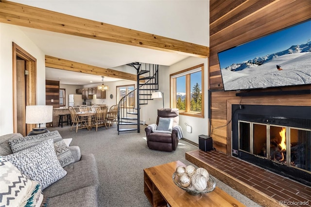 9430 Ryan Gulch Rd Unit 9450, Silverthorne, CO 80498 - living area featuring a lit fireplace, stairs, beam ceiling, a chandelier, and carpet flooring