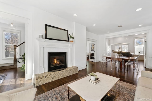 living room with plenty of natural light and dark wood-type flooring