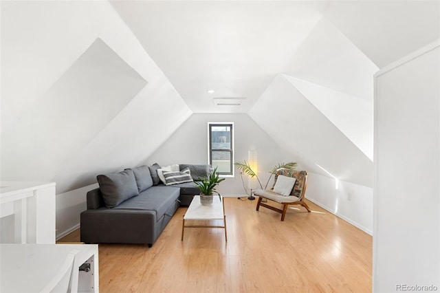 living room featuring lofted ceiling and light hardwood / wood-style flooring