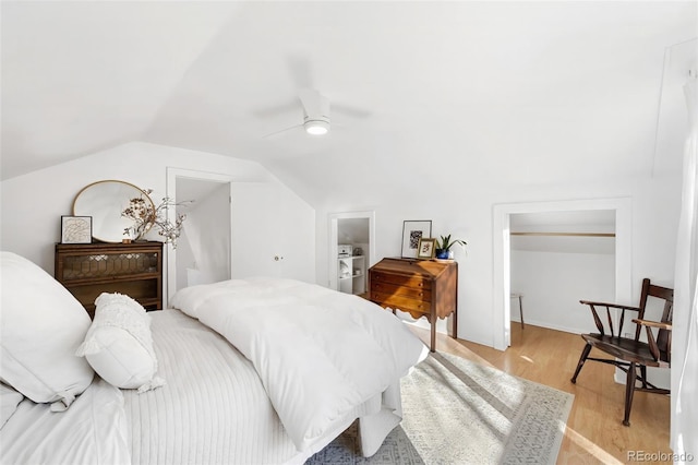 bedroom with light hardwood / wood-style floors, ceiling fan, and lofted ceiling