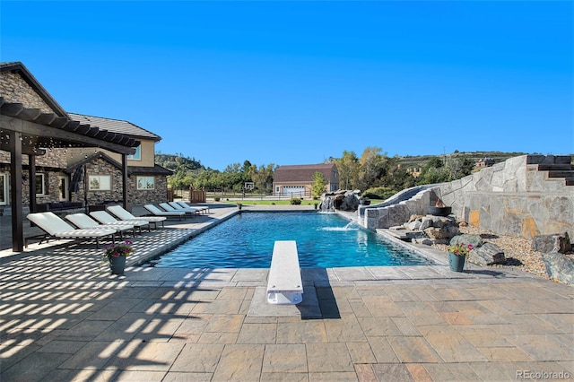 view of pool with pool water feature, a pergola, a diving board, and a patio area