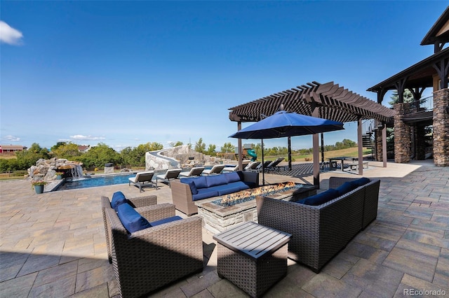 view of patio / terrace with pool water feature, a pergola, and an outdoor living space with a fire pit