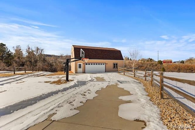 view of home's exterior with a garage, an outdoor structure, and a rural view