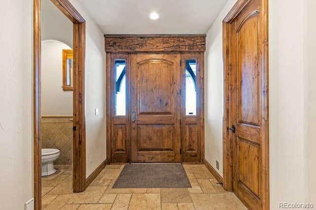 foyer entrance with tile walls