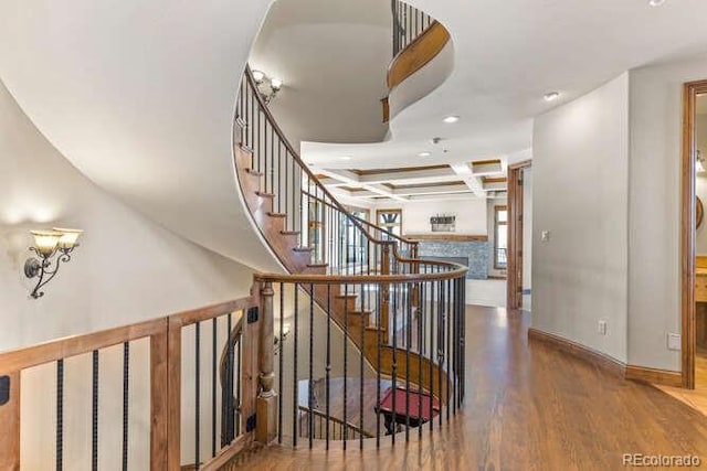 staircase with coffered ceiling, hardwood / wood-style flooring, and beamed ceiling