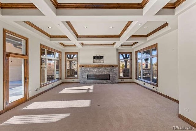 unfurnished living room with coffered ceiling, a stone fireplace, beam ceiling, and light colored carpet