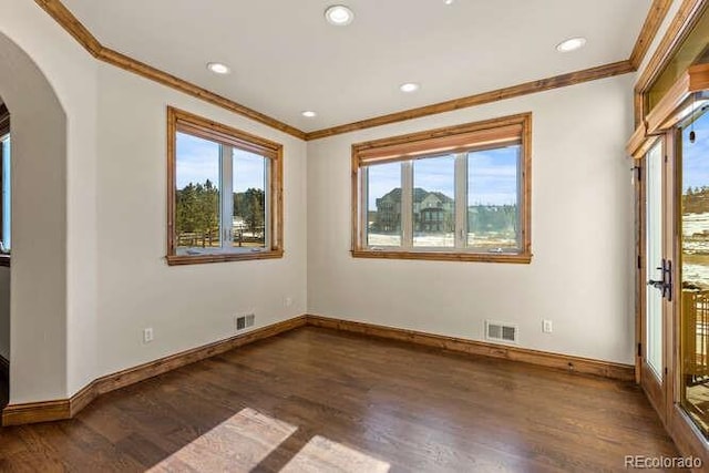 unfurnished room featuring dark hardwood / wood-style flooring, plenty of natural light, and ornamental molding