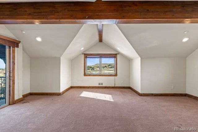 bonus room with lofted ceiling with beams and light colored carpet