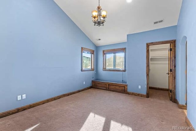 unfurnished bedroom with vaulted ceiling, light carpet, and a notable chandelier