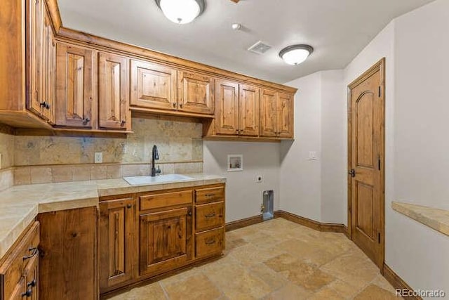 washroom with cabinets, washer hookup, sink, and electric dryer hookup