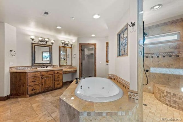 bathroom featuring vanity and independent shower and bath