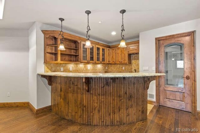 bar featuring pendant lighting, tasteful backsplash, and dark hardwood / wood-style floors