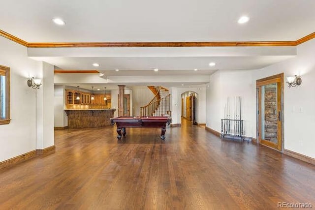 playroom featuring beamed ceiling, ornamental molding, dark wood-type flooring, and pool table