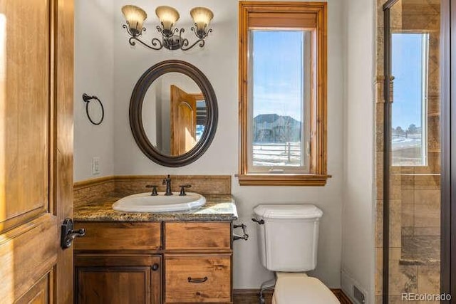 bathroom featuring vanity, plenty of natural light, and toilet