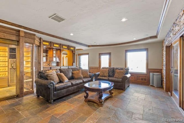 living room with crown molding and a tray ceiling