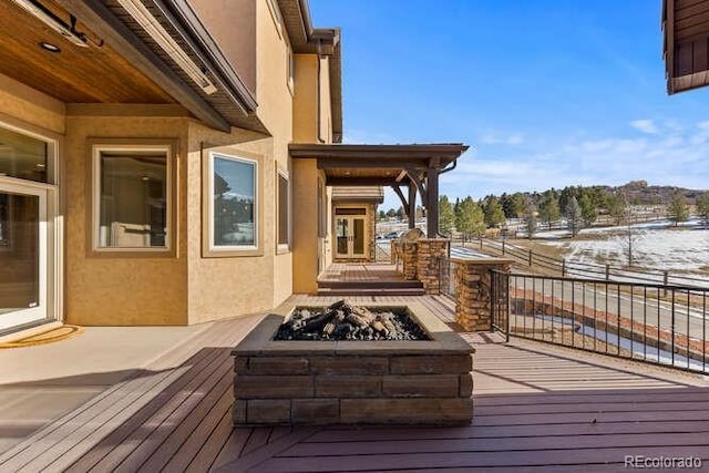 snow covered deck featuring an outdoor fire pit