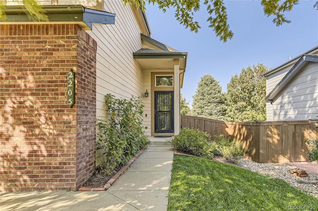 entrance to property with a lawn