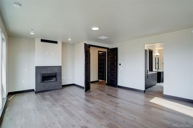 unfurnished living room with baseboards and light wood-style floors