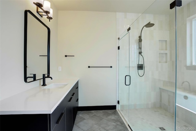 bathroom with a shower stall, baseboards, and vanity