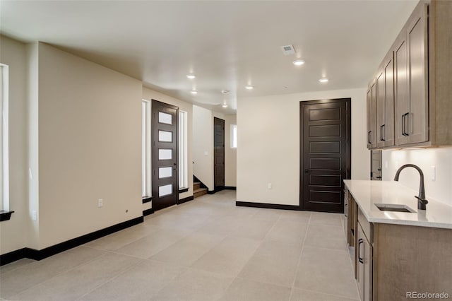 kitchen featuring visible vents, baseboards, recessed lighting, a sink, and light tile patterned floors