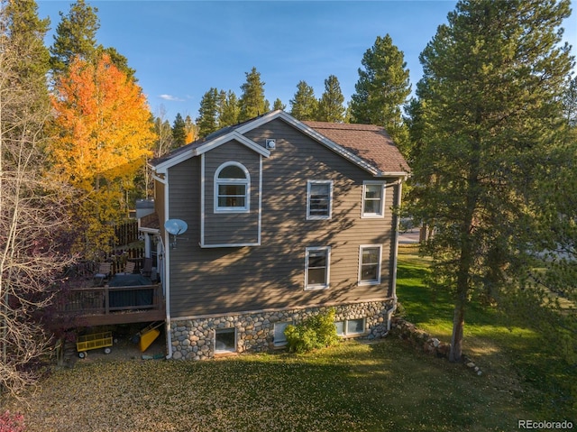 view of side of property with a lawn and a deck