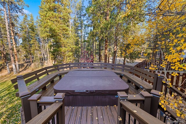 wooden deck with a covered hot tub