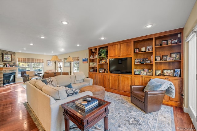 living room featuring a stone fireplace and light wood-type flooring