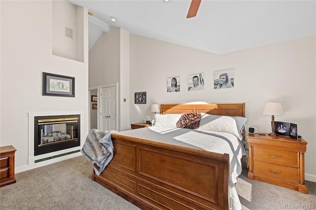 carpeted bedroom featuring ceiling fan and high vaulted ceiling