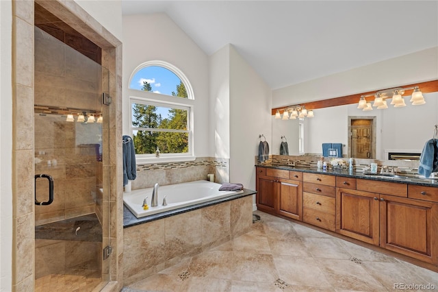 bathroom featuring vanity, independent shower and bath, and lofted ceiling