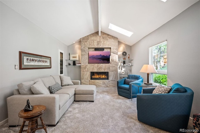 living area with a skylight, a tiled fireplace, carpet floors, and built in features