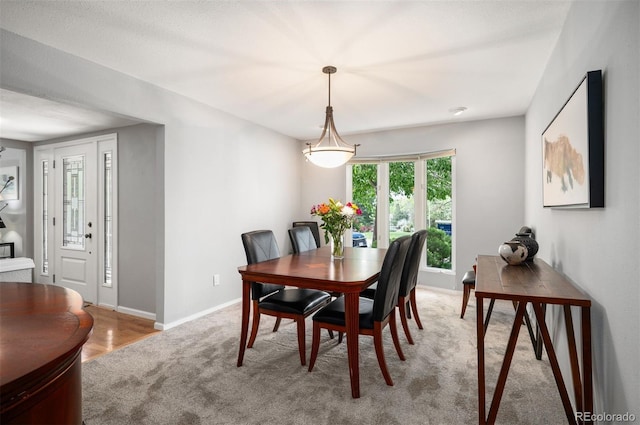 dining space with carpet floors and baseboards