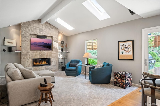 living area featuring a skylight, a high end fireplace, wood finished floors, and baseboards