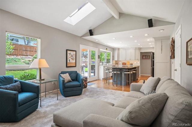 living room featuring a skylight, recessed lighting, beamed ceiling, and high vaulted ceiling