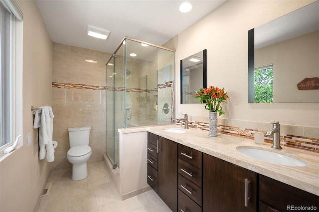bathroom with toilet, a stall shower, double vanity, tasteful backsplash, and recessed lighting