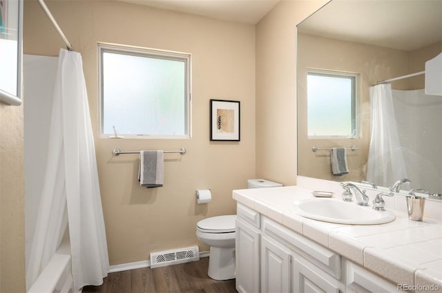 full bath with toilet, wood finished floors, vanity, and baseboards