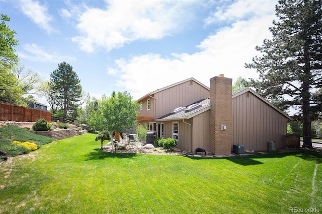 7414 S Monroe Ct, Centennial, CO 80122 - back of house featuring a chimney, cooling unit, and board and batten siding