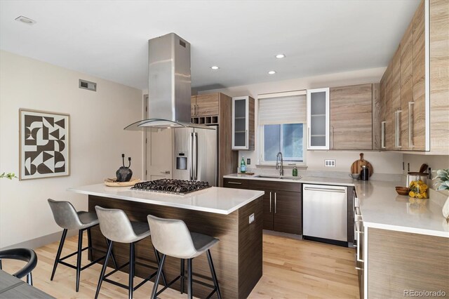3615 Navajo St, Denver, CO 80211 - kitchen featuring stainless steel appliances, a sink, island exhaust hood, a kitchen bar, and a center island