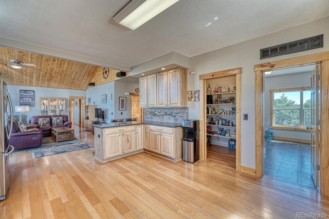 2680 Wild Bill Blvd, Westcliffe, CO 81252 - kitchen featuring a peninsula, light wood-style flooring, dark countertops, open floor plan, and light brown cabinetry