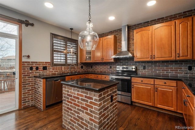 kitchen with wall chimney range hood, appliances with stainless steel finishes, a wealth of natural light, and dark wood-type flooring