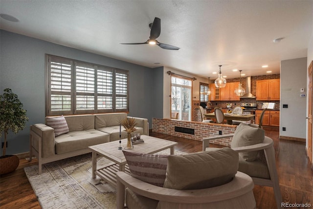 living area featuring dark wood finished floors, baseboards, and ceiling fan