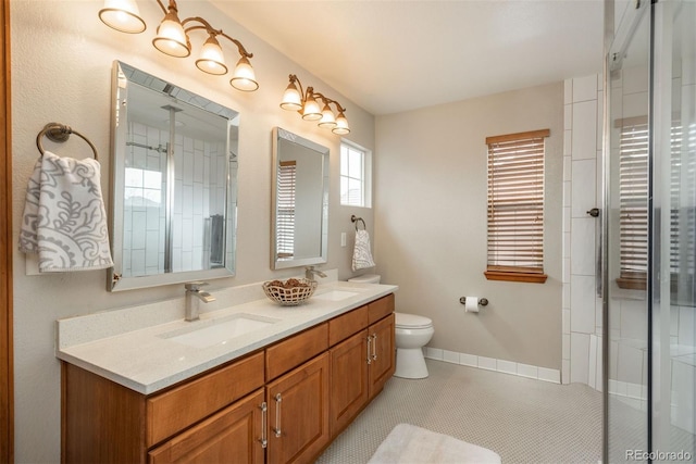 full bathroom featuring baseboards, a sink, toilet, and double vanity