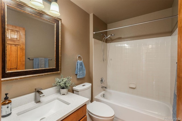 bathroom featuring toilet, a textured wall, washtub / shower combination, and vanity