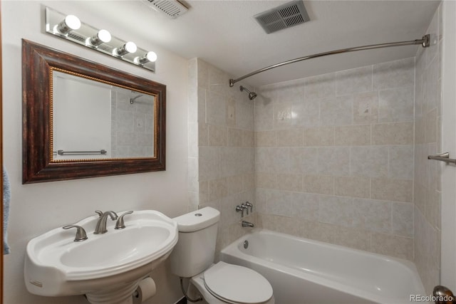 bathroom featuring toilet, visible vents, a sink, and shower / bathing tub combination