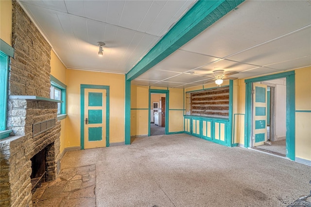 unfurnished living room featuring carpet flooring, ceiling fan, and a fireplace