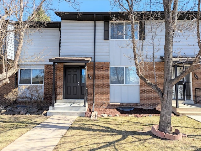 view of front of home with brick siding and a front lawn