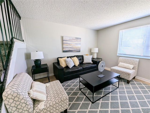 living area featuring a textured ceiling and baseboards