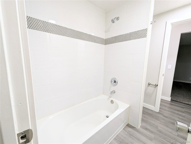 bathroom featuring bathtub / shower combination, wood finished floors, and baseboards