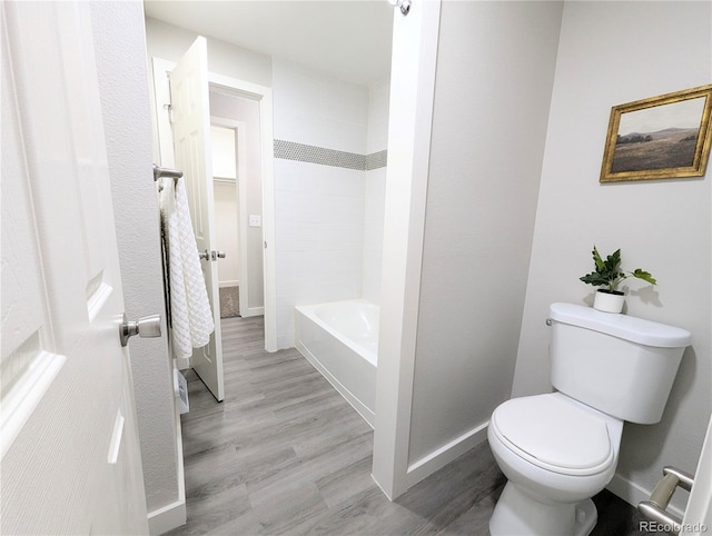 bathroom featuring toilet, wood finished floors, and baseboards