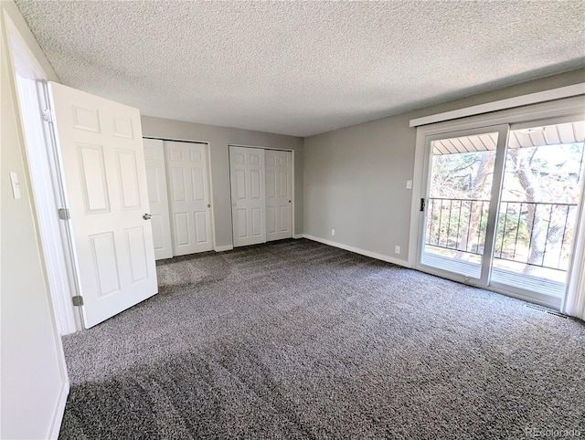 unfurnished bedroom with baseboards, carpet floors, two closets, and access to outside