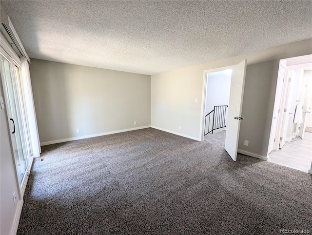 unfurnished bedroom featuring a textured ceiling, baseboards, and dark colored carpet